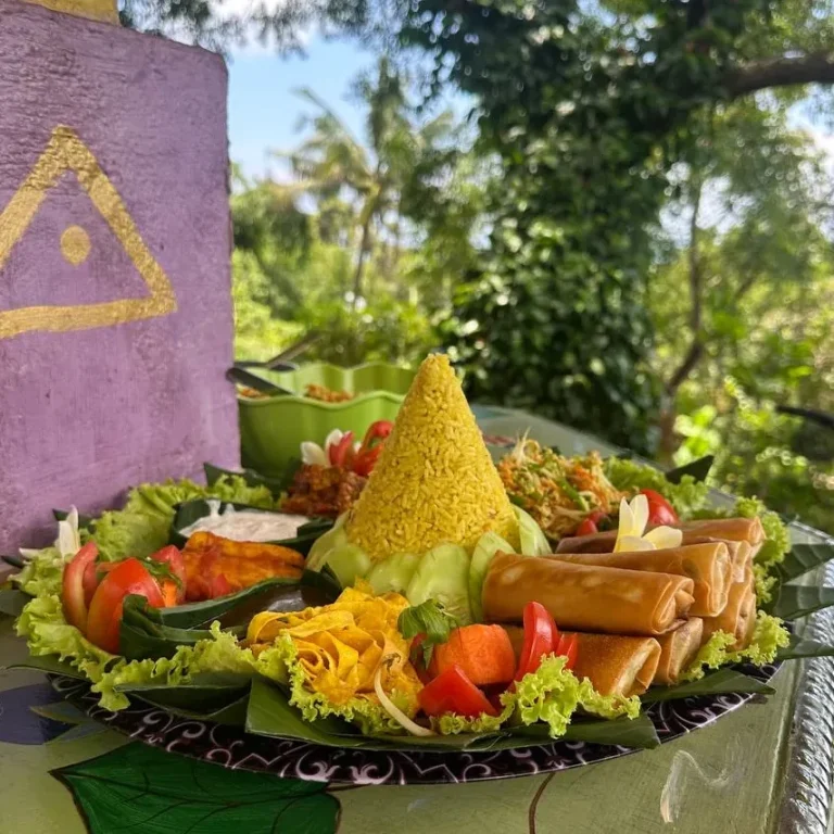 Ein buntes, vegetarisches Buffet mit Reis, frischem Gemüse und einer grünen Dekoration.