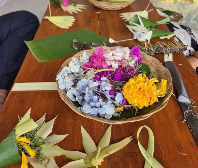 Bunte Blumen in runden, geflochtenen Schalen auf einem Holztisch arrangiert.