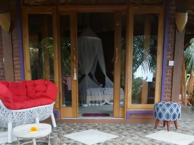 Eingang zu einem gemütlichen Raum mit einer roten Couch und einem blauen Hocker.