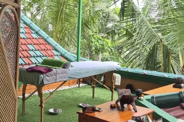 Ein entspannender Außenbereich mit Massageliegen und tropischen Pflanzen.