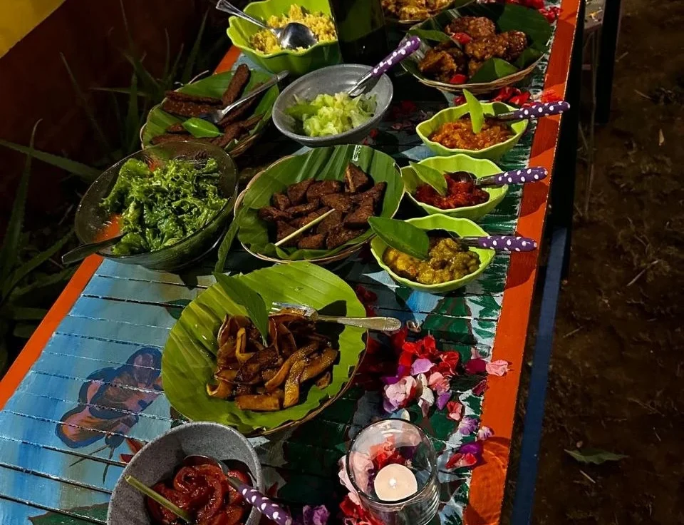 Bunt dekorierter Tisch mit verschiedenen traditionellen Gerichten und frischen Zutaten.