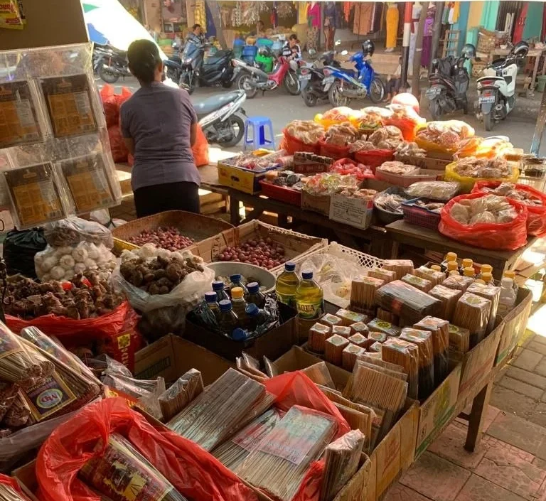 Marktstand voll mit frischen Lebensmitteln, Gewürzen und abgepackten Waren.